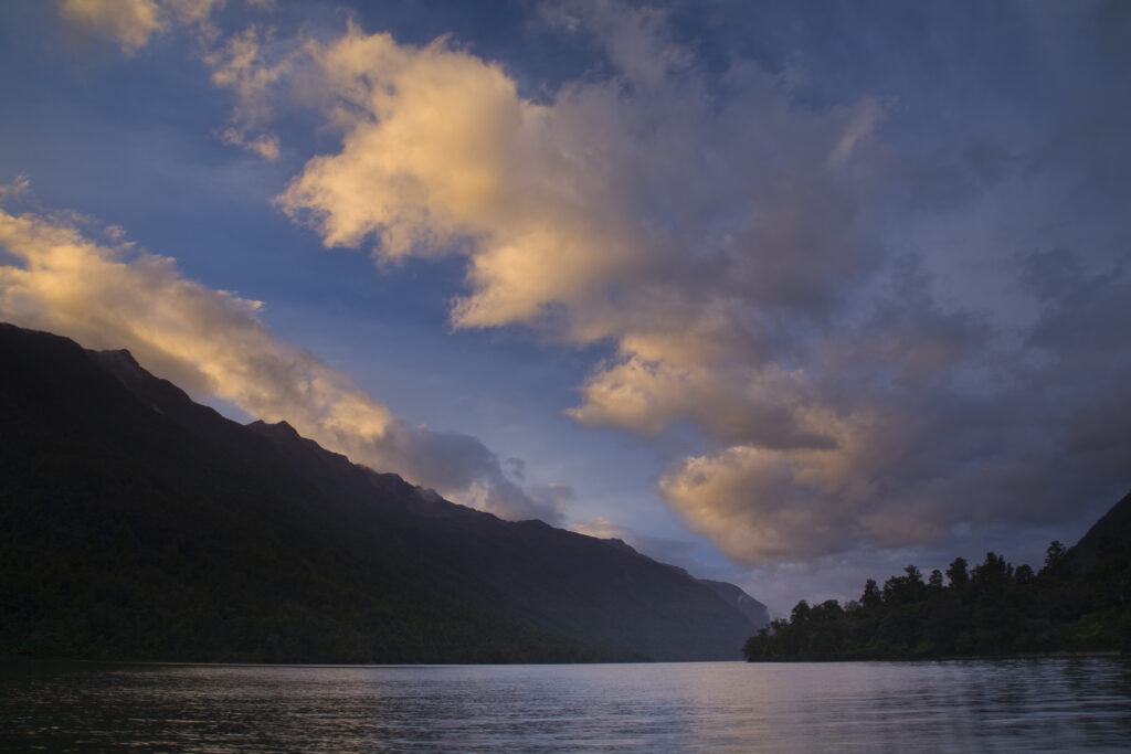 New Zealand, Southland, Fiordland National Park. Colurful clouds at sunset above Lake Alabaster, on the Hollyford Track.