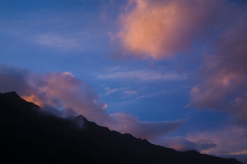 New Zealand, Southland, Fiordland National Park. Colurful clouds at sunset above Lake Alabaster, on the Hollyford Track.