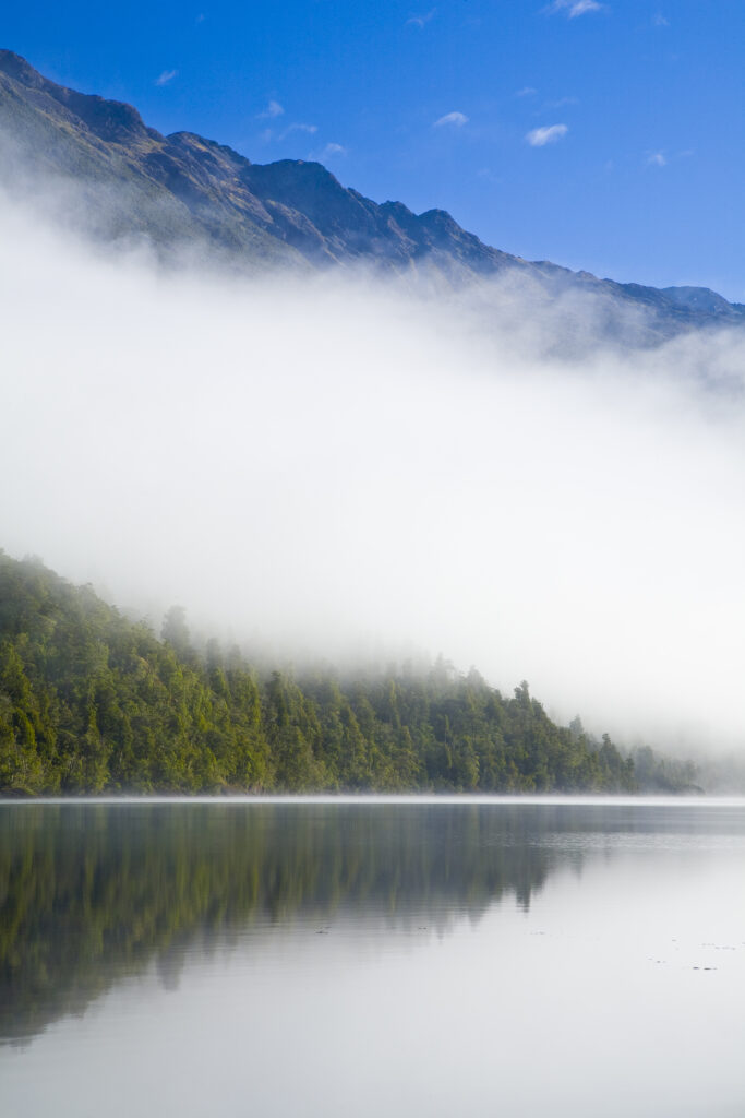 New Zealand, Southland, Fiordland National Park. Autumn mist clears from Lake Alabaster, on the Hollyford Track.