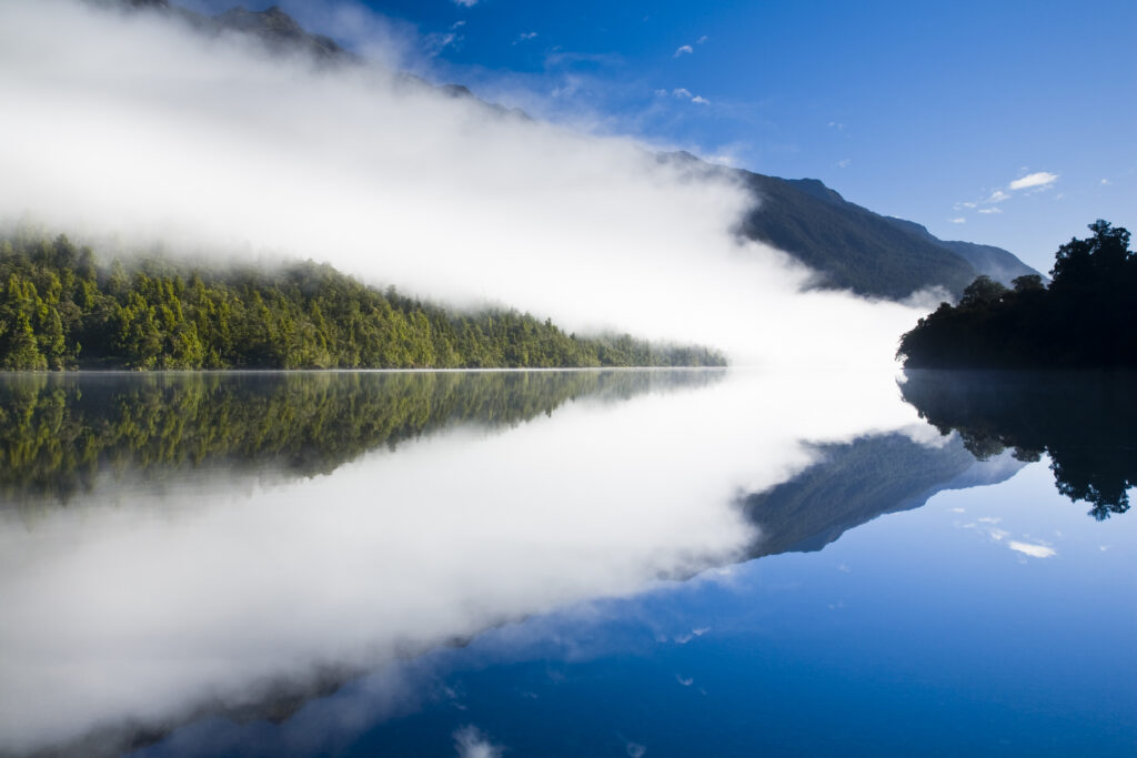 New Zealand, Southland, Fiordland National Park. Autumn mist clears from Lake Alabaster, on the Hollyford Track.