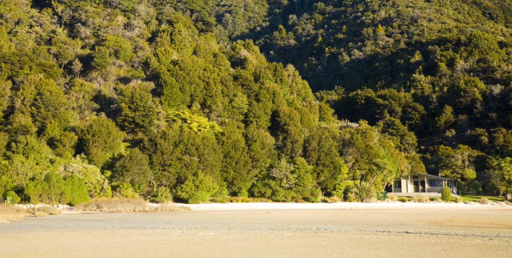 New Zealand, Nelson, Abel Tasman National Park. Awaroa Hut located on the Awaroa inlet at the Awaroa Bay, part of the coastal great walk.