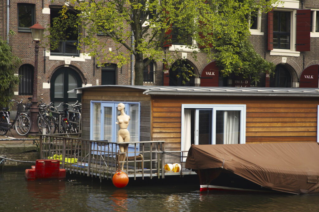 Netherlands, North Holland, Amsterdam. Boat house and Mannequin, located on a canal in Amsterdam City.