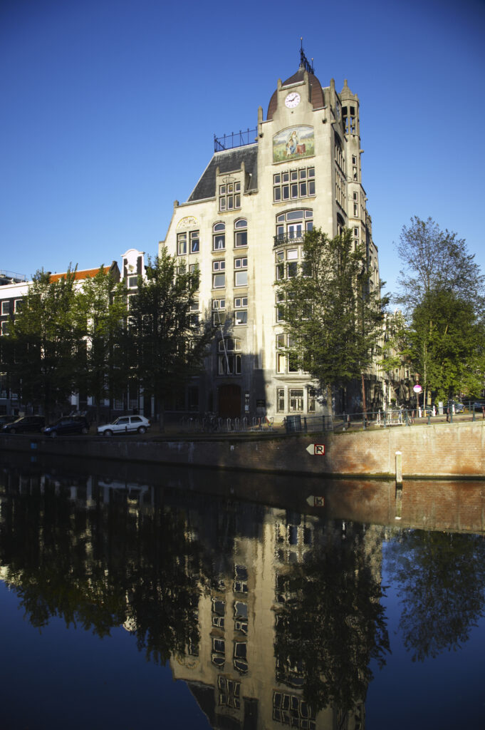 Netherlands, North Holland, Amsterdam. Typical architecture of Amsterdam city reflected in the still waters of an Amsterdam Canal.