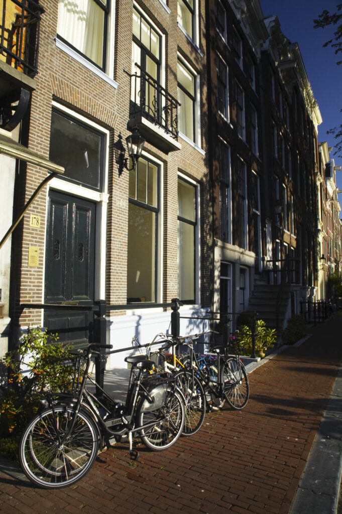 Netherlands, North Holland, Amsterdam. Bicycles chained to railings outside a building in Amsterdam City.
