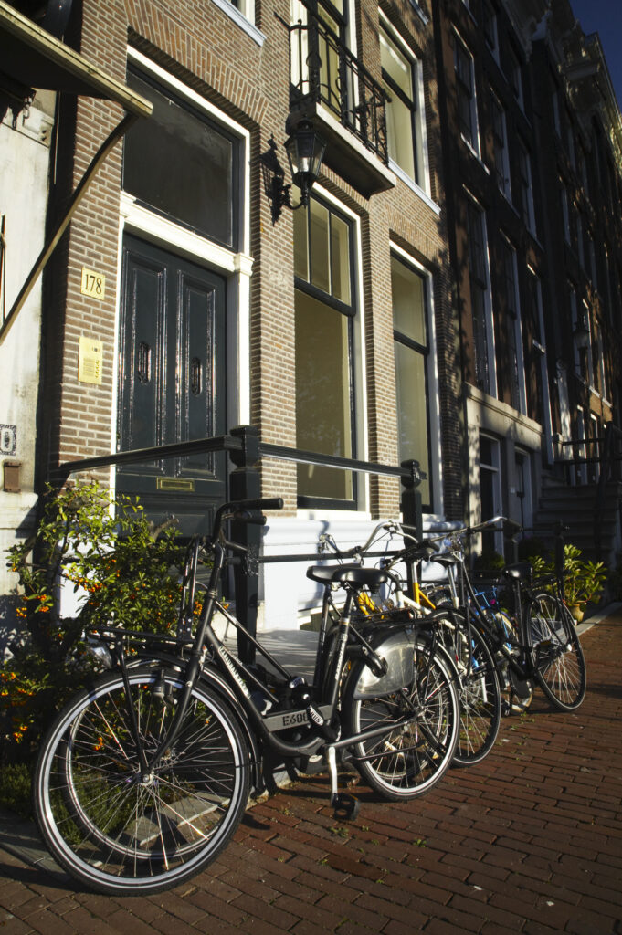 Netherlands, North Holland, Amsterdam. Bicycles chained to railings outside a building in Amsterdam City.