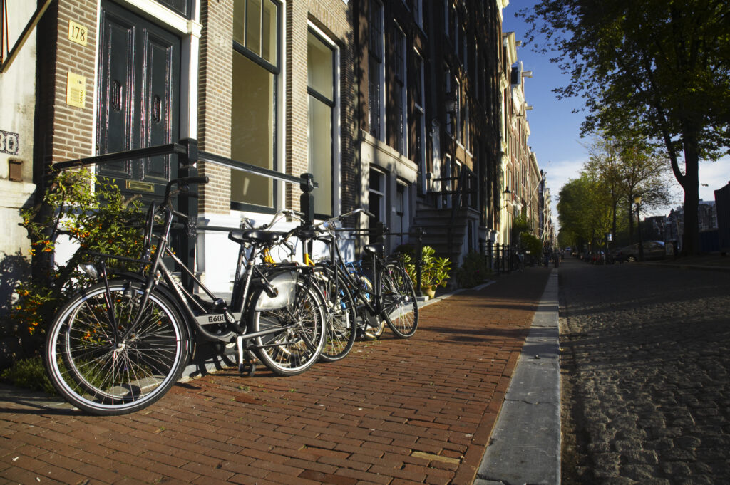 Netherlands, North Holland, Amsterdam. Bicycles chained to railings outside a building in Amsterdam City.