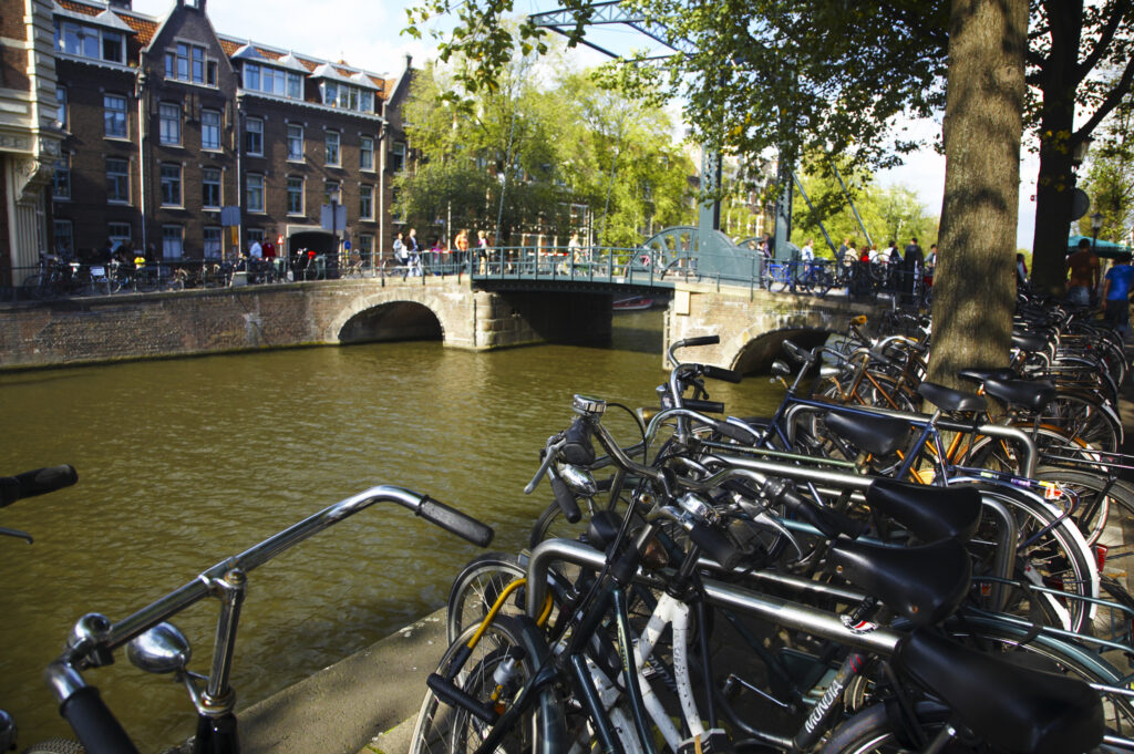Netherlands, North Holland, Amsterdam. Bicycles left alongside the banks of the River Amstel in Amsterdam City.