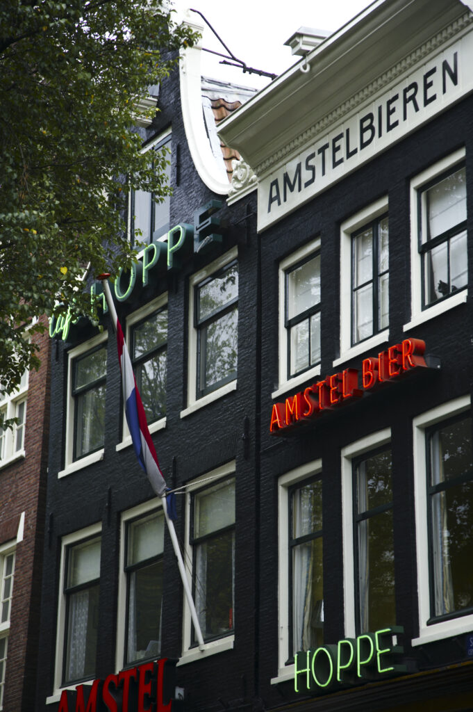 Netherlands, North Holland, Amsterdam. Neon beer signs on the front of a cafe / restaurant building in Amsterdam City.