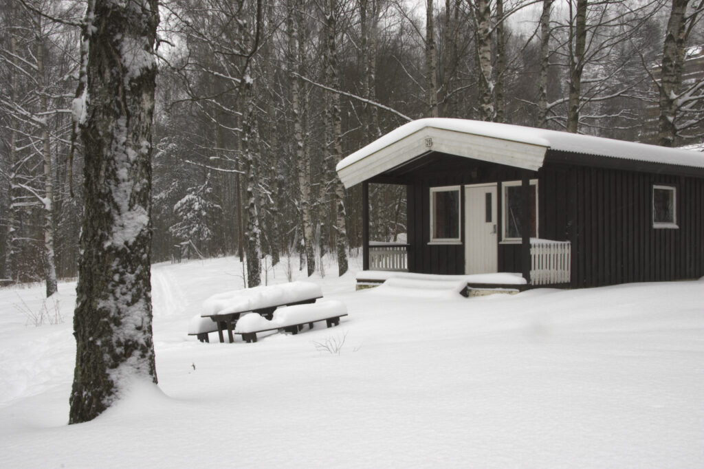 Norway, Oslo, Oslo City. Snow covered wooden camping hut / cabin in the Bogstad camping ground in Oslo city.