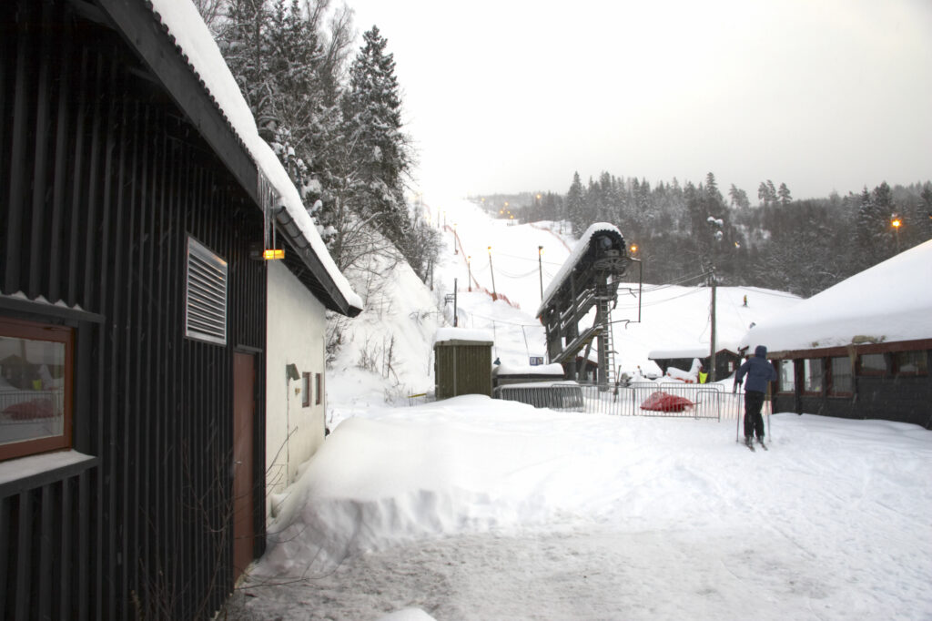 Norway, Oslo, Oslo City. Wooden buildings and ski tow bars at Wyller in the Tryvann Ski field, after a snowfall in Oslo Forest.