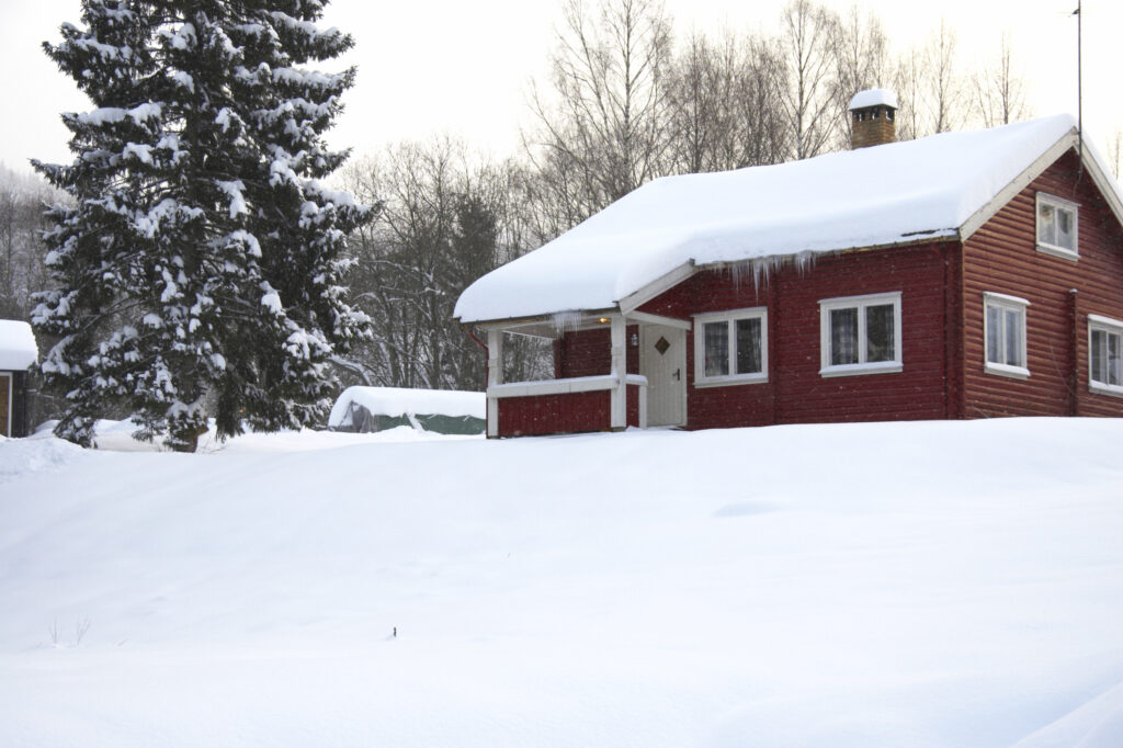 Norway, Oslo, Oslo City. Snow covered wooden house after a heavy snowfall near the Tryvann Ski field in Oslo Forest.