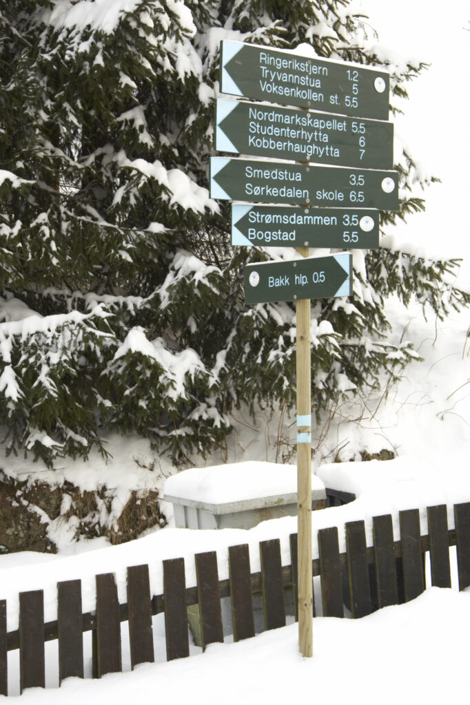 Norway, Oslo, Oslo City. Snow covered public footpath sign after a heavy snowfall near the Tryvann Ski field in Oslo Forest.
