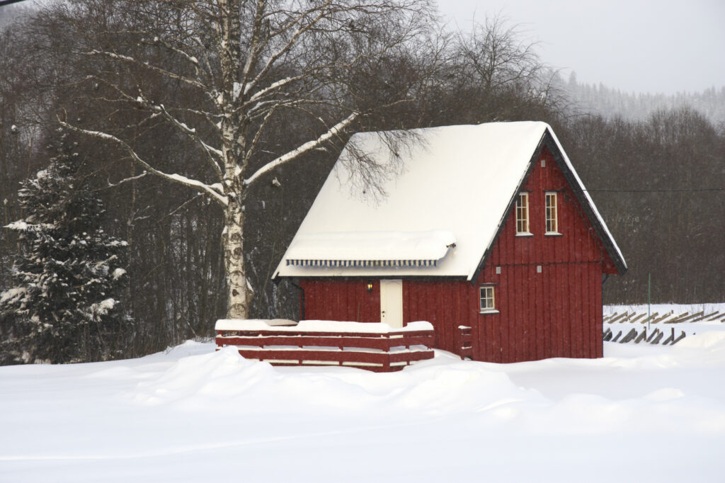 Norway, Oslo, Oslo City. Snow covered wooden house after a heavy snowfall near the Tryvann Ski field in Oslo Forest.