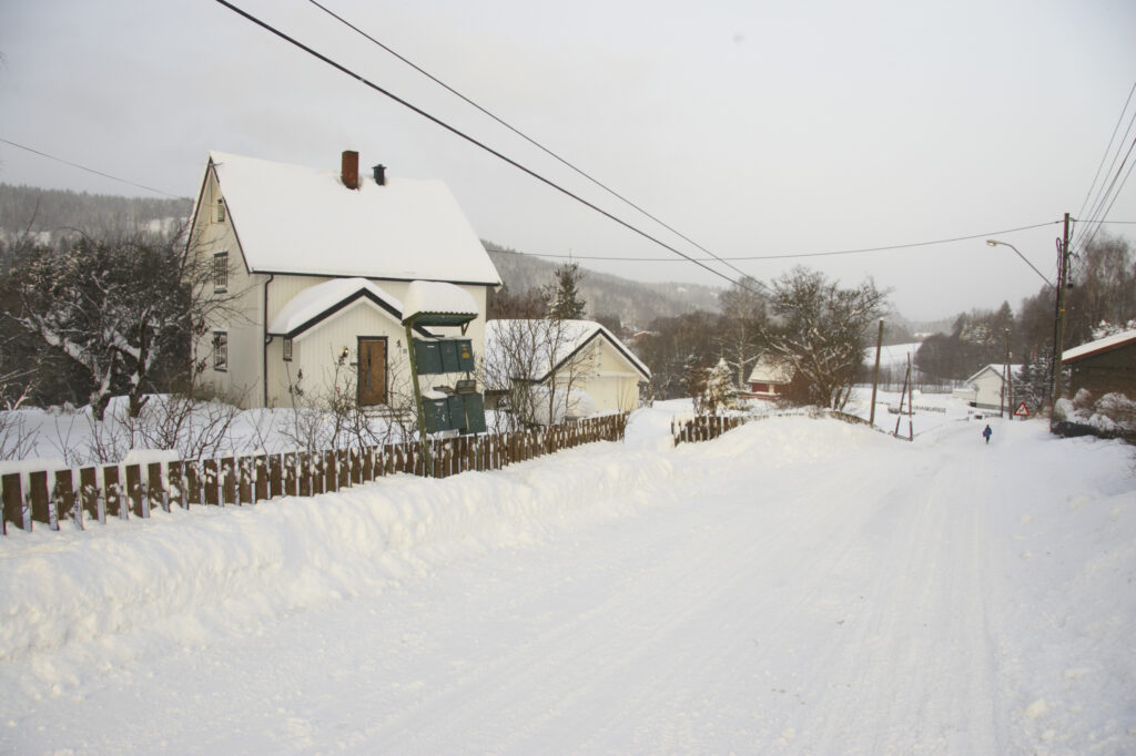 Norway, Oslo, Oslo City. Wooden house aside a country road after a heavy snowfall near the Tryvann Ski field in the Oslo forest