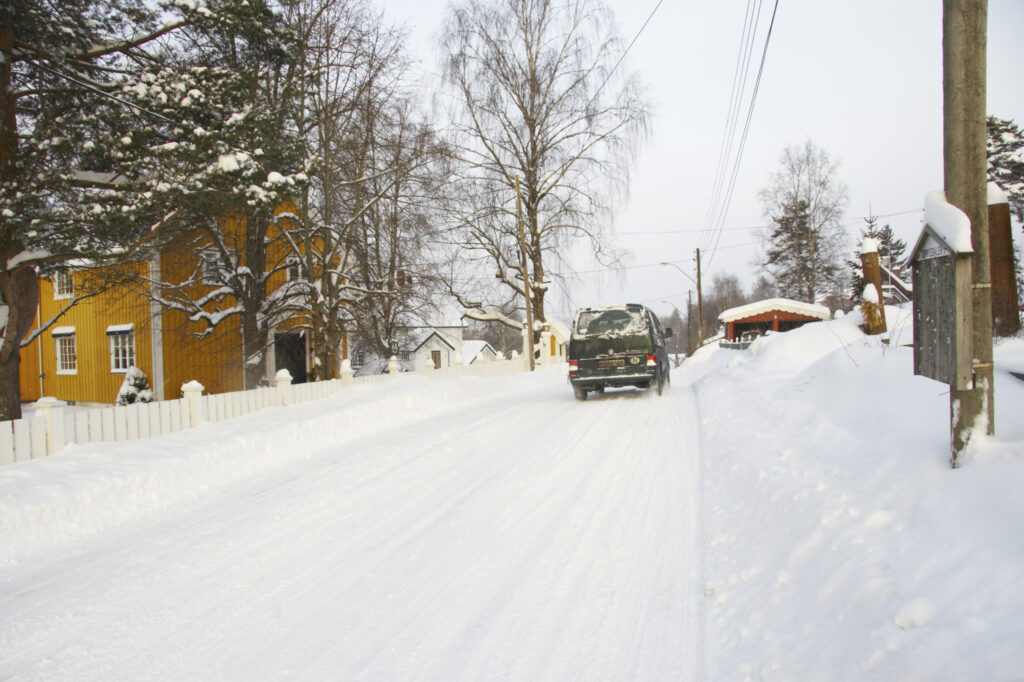 Norway, Oslo, Oslo City. Van driving down a country road after a heavy snowfall near the Tryvann Ski field in the Oslo forest.