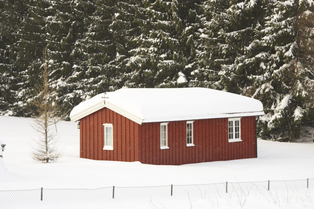 Norway, Oslo, Oslo City. Snow covered wooden house after a heavy snowfall near the Tryvann Ski field in Oslo Forest.