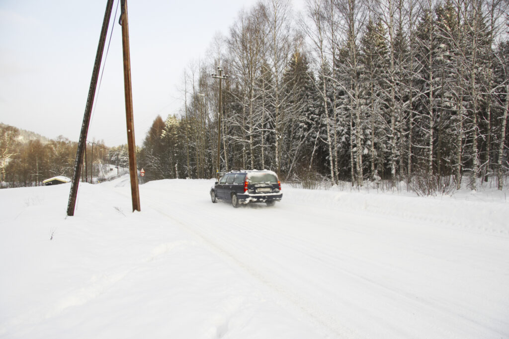 Norway, Oslo, Oslo City. A car driving along a road after a heavy snowfall near the Tryvann Ski field.
