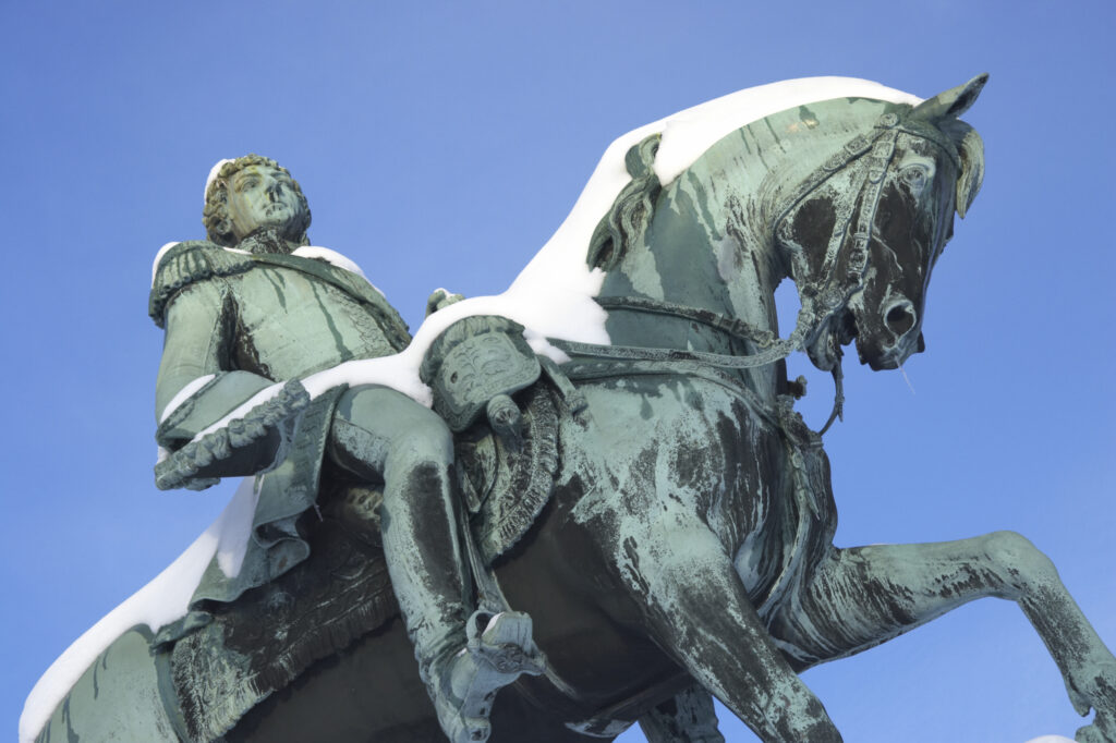 Norway, Oslo, Oslo City. Statue of King Karl Johan in the grounds of the Royal Palace, after a heavy winter snow fall.