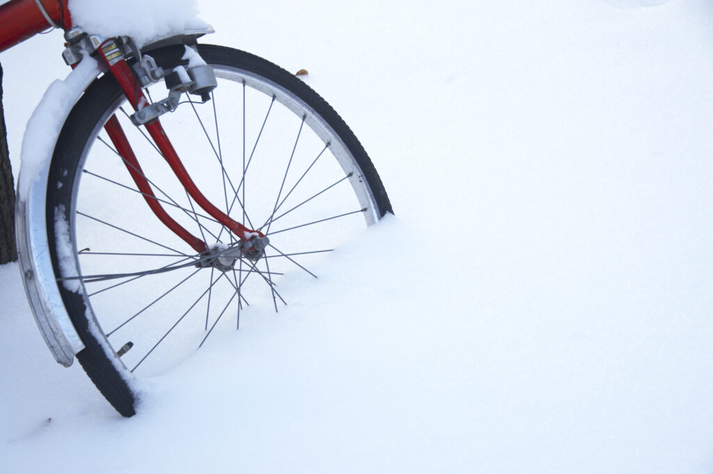 Norway, Oslo, Oslo City. The front wheel of a bike abandoned after a heavy snowfall.