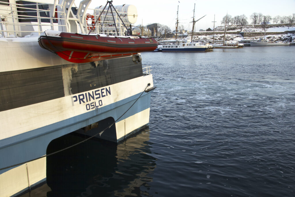 Norway, Oslo, Oslo City. Late afternoon winter light illuminates boats moored at the Aker Quay on the Oslofjorden Fjord.