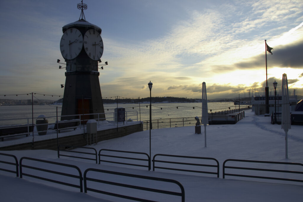 Norway, Oslo, Oslo City. Late afternoon winter light illuminates the snow coverered Aker Quay and the Oslofjorden Fjord.