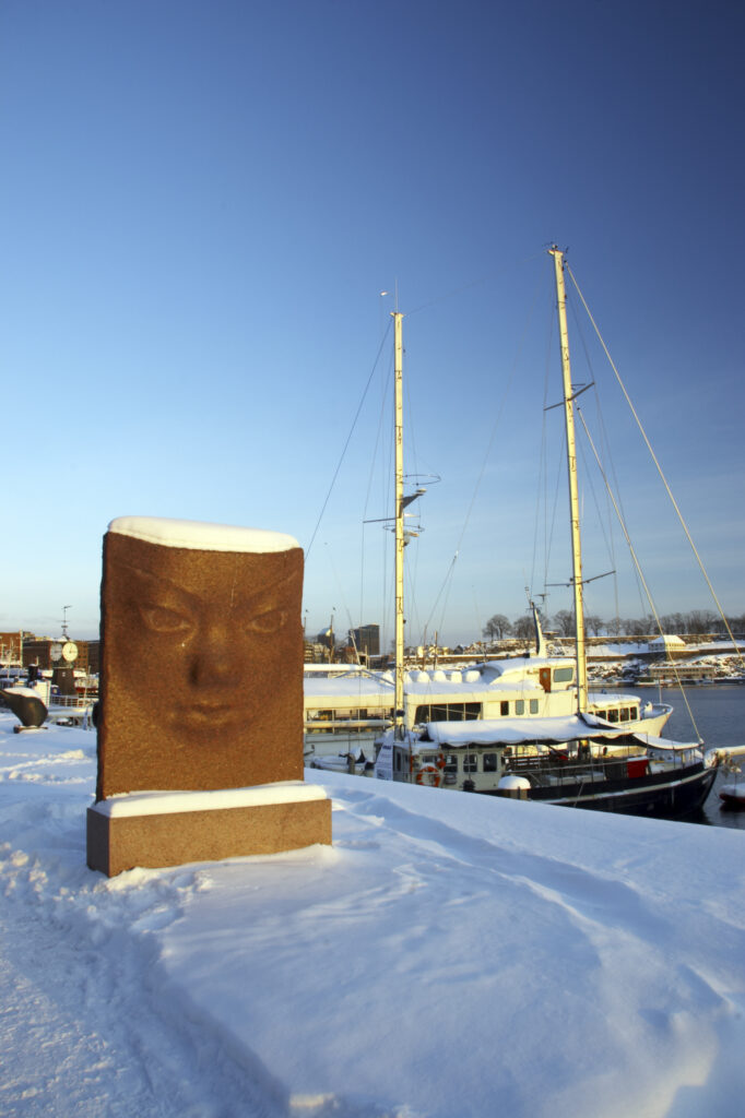 Norway, Oslo, Oslo City. Late afternoon winter light illuminates the snow coverered Aker Quay and the Oslofjorden Fjord.
