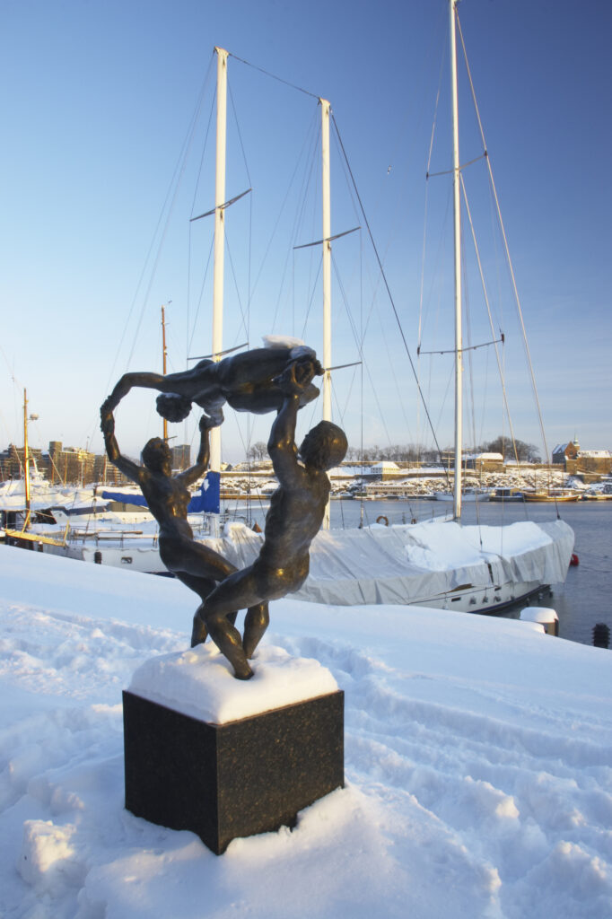 Norway, Oslo, Oslo City. Late afternoon winter light illuminates the snow coverered Aker Quay and the Oslofjorden Fjord.