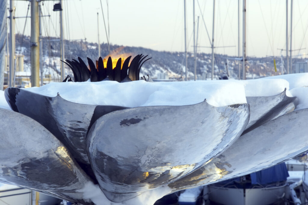 Norway, Oslo, Oslo City. Flames of peace monument on the snow coverered Aker Quay and Oslofjorden Fjord