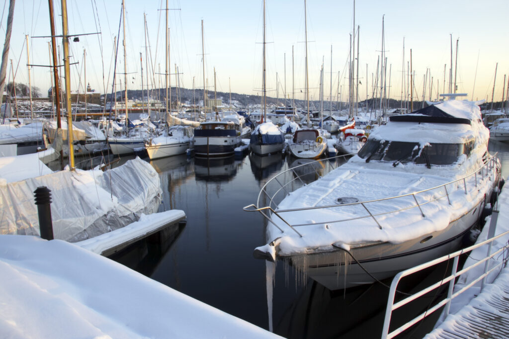 Norway, Oslo, Oslo City. Late afternoon winter light illuminates boats moored at the Aker Quay on the Oslofjorden Fjord.