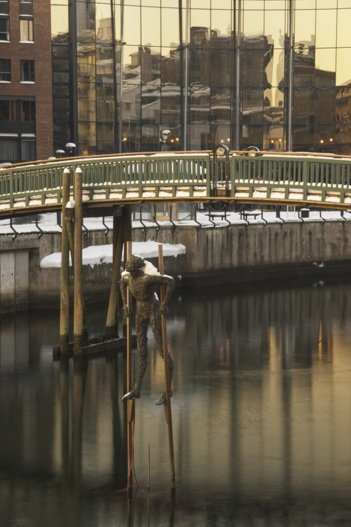 Norway, Oslo, Oslo City. A winter scene of a bridge and a statue in a canal near Aker Quay, in Oslo city.