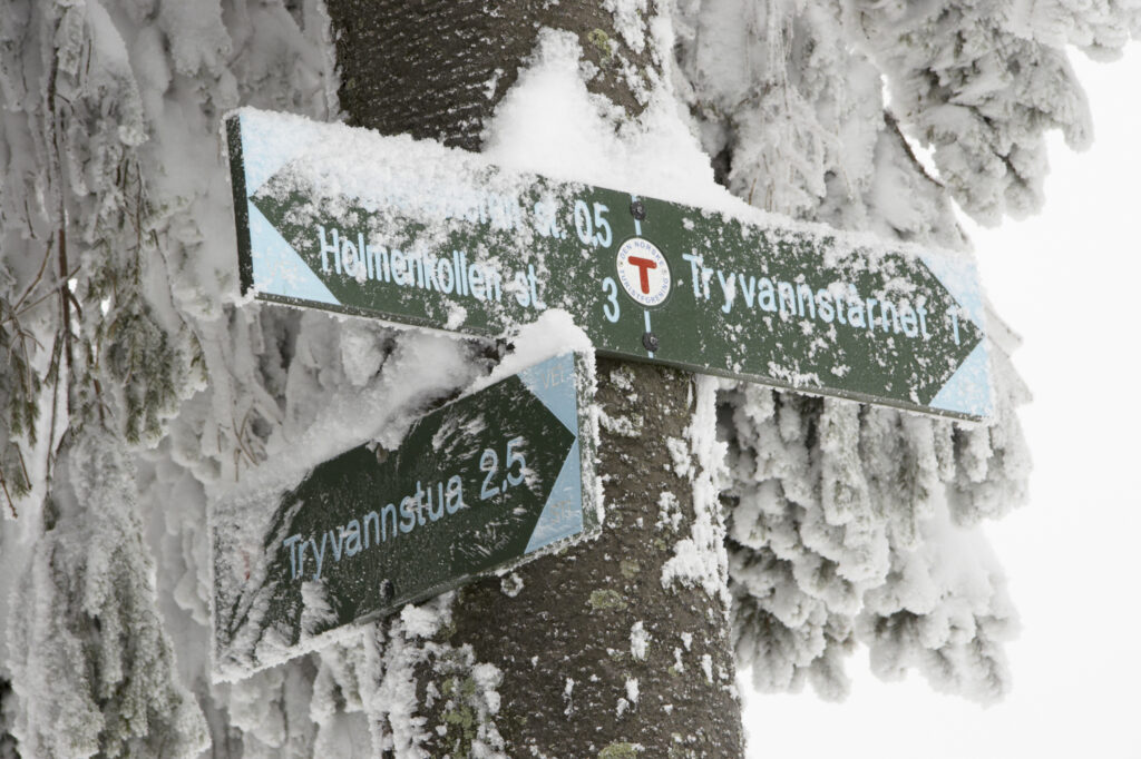 Norway, Oslo, Holmenkollen. A snow covered route direction sign found in the Holmenkollen area near to the Tryvann Ski-field.