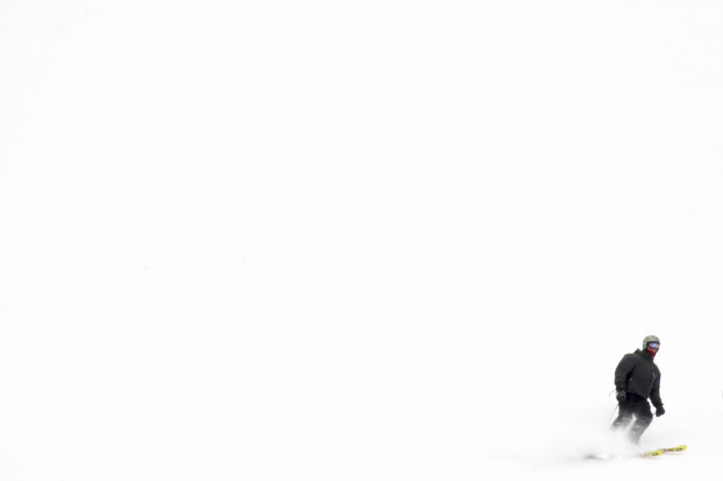 Norway, Oslo, Holmenkollen. A skier enjoys a winter snowfall on the slopes of the Tryvann Skifield, in the Holmenkollen area.
