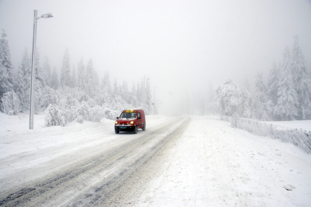 Norway, Oslo, Holmenkollen. A postal service van using a country road heading up to the upper slopes of the Tryvann Skifield