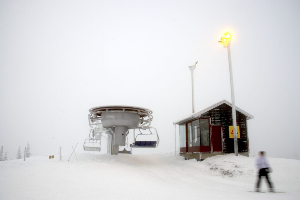 Norway, Oslo, Holmenkollen. Snow boarders skiing of a chairlift in the Tryvann Skifield, in the Holmenkollen area.
