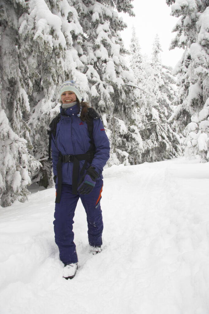 Norway, Oslo, Holmenkollen. Female hiker walking through snow covered forest in the Holmenkollen area near to Tryvann Ski-field