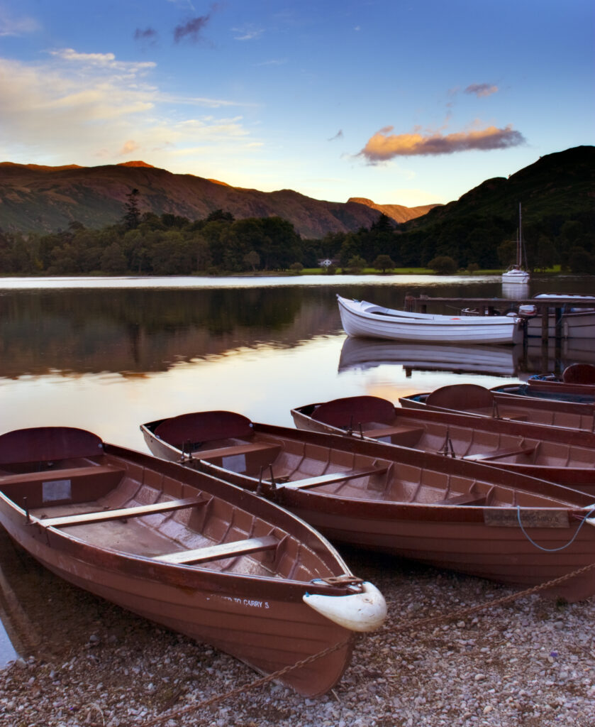England, Cumbria, Ullswater. Rowing boats and the sweeping vista of Ullswater part of the Lake District National Park