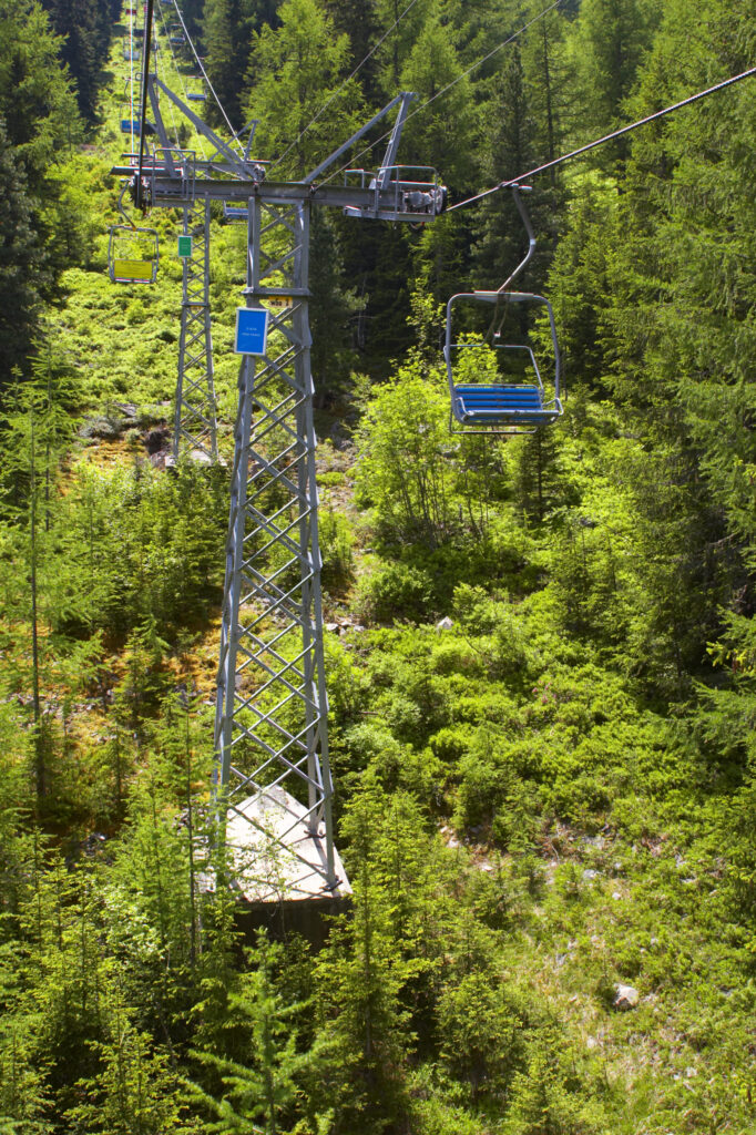 Switzerland Valais Val d Arpette Alpine chairlift high above woodland near to the Lac de Champex during the summer months.