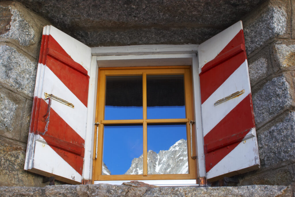 Switzerland Valais Val Ferret. Mountains reflected in the windows of the Cabane de l'A Neuve mountain refuge