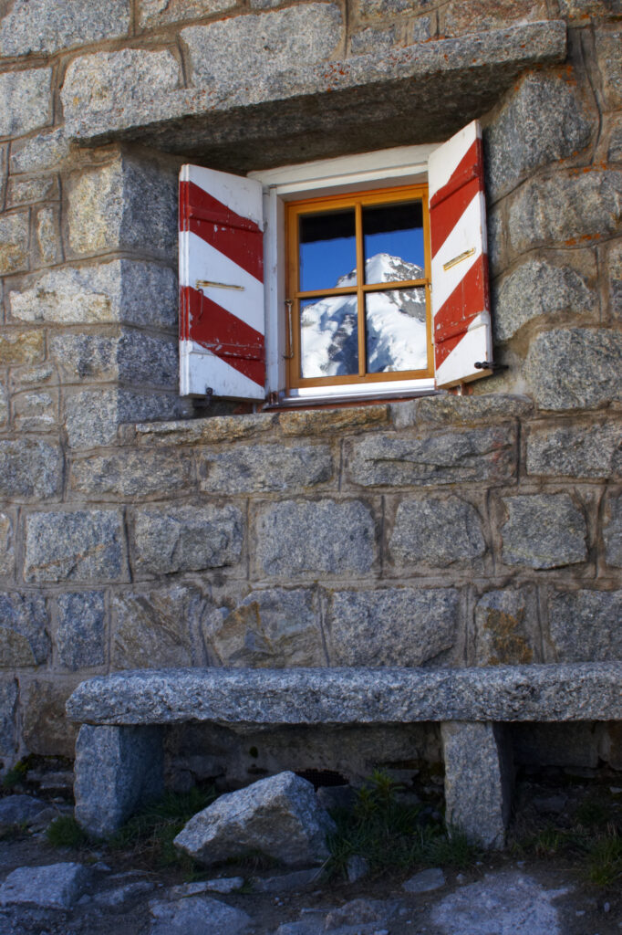 Switzerland Valais Val Ferret. Mountains reflected in the windows of the Cabane de l'A Neuve mountain refuge