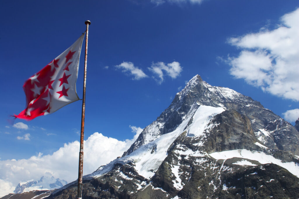 Switzerland Valais, Matterhorn. The Matterhorn and a flagviewed from outside the Schonbielhutte alpine hut