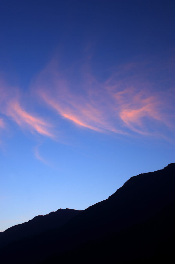 Switzerland Valais Val Ferret. Pink clouds above a dramatic mountain landscape near the village of La Fouly