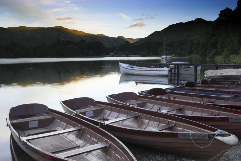 England Cumbria Ullswater Rowing boats and the sweeping vista of Ullswater part of the Lake District National Park