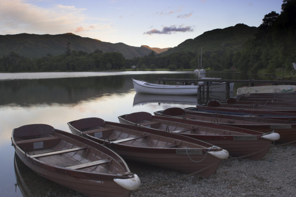 England Cumbria Ullswater Rowing boats and the sweeping vista of Ullswater part of the Lake District National Park