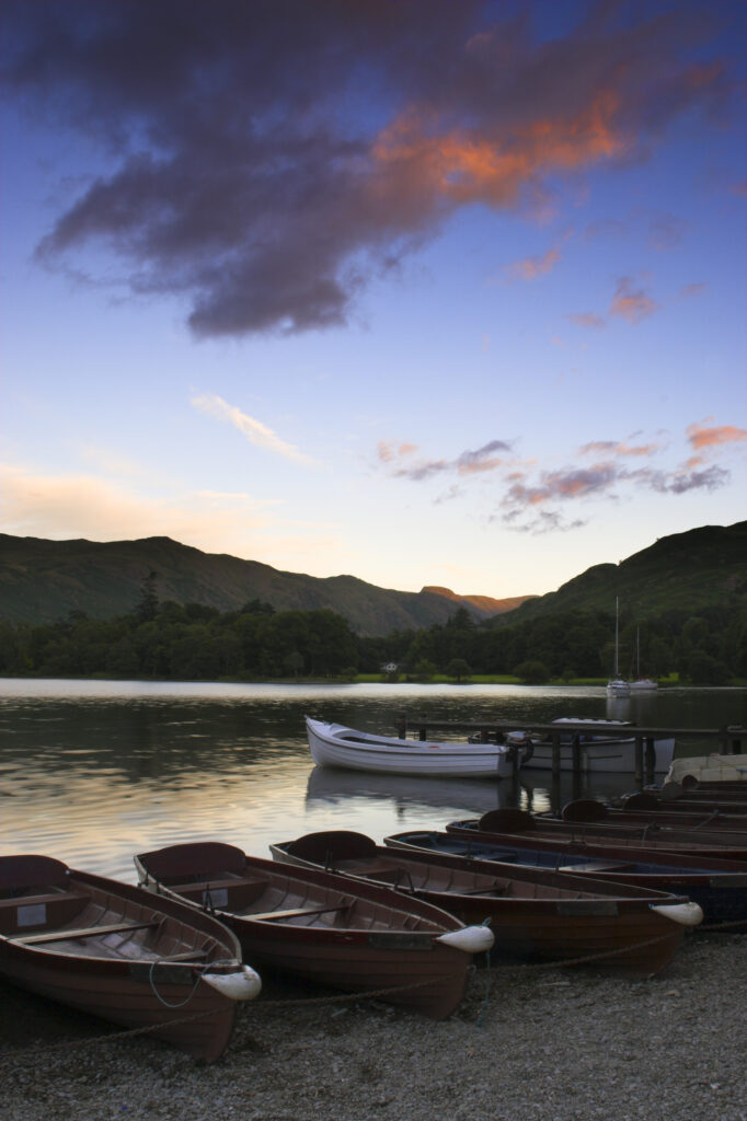 England Cumbria Ullswater Rowing boats and the sweeping vista of Ullswater part of the Lake District National Park