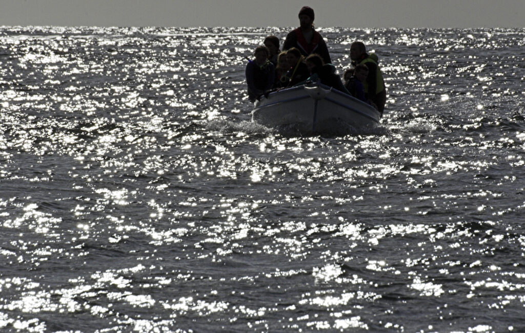 Ireland County Kerry Dingle Peninsula A group of snorklers on a small boat looking over Dingle Bay search for Fungi the dolphin