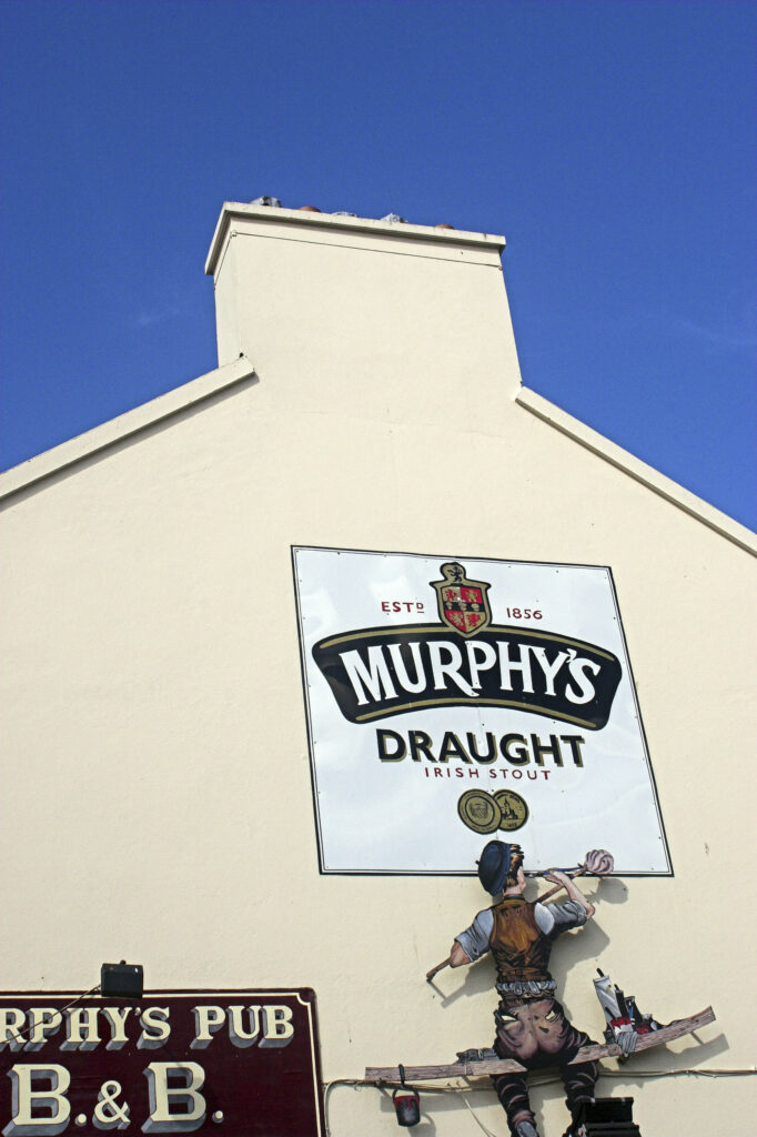 Ireland County Kerry Dingle A large sign advertising Murphys stout on the side of a pub in Dingle