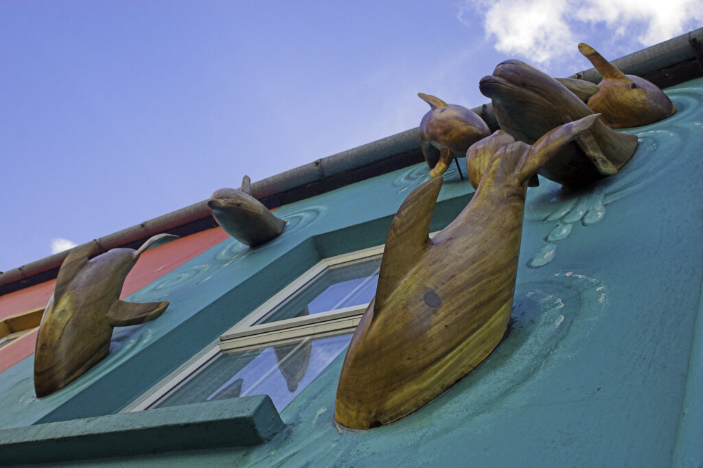 Ireland County Kerry Dingle A dolphin theme on the side of a shop in Dingle home to Fungi the dolphin