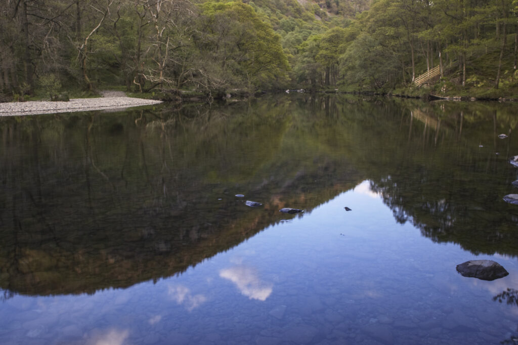 England, Cumbria, Lake District National Park. Borrowdale mountains reflected in the still waters of the River Derwent