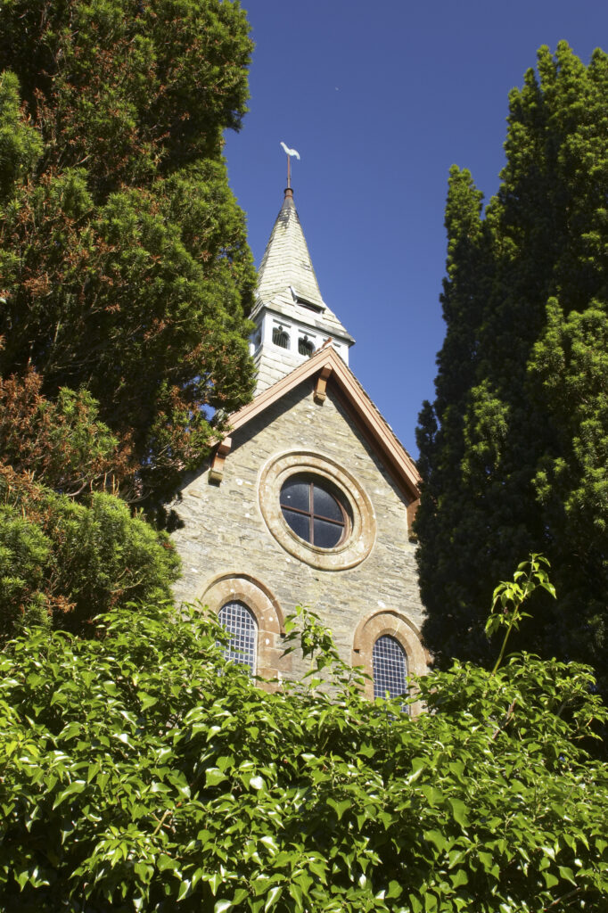 England, Cumbria, Osmotherly. The church of St John, near Ulverston, surrounded by the summer colours of foliage.