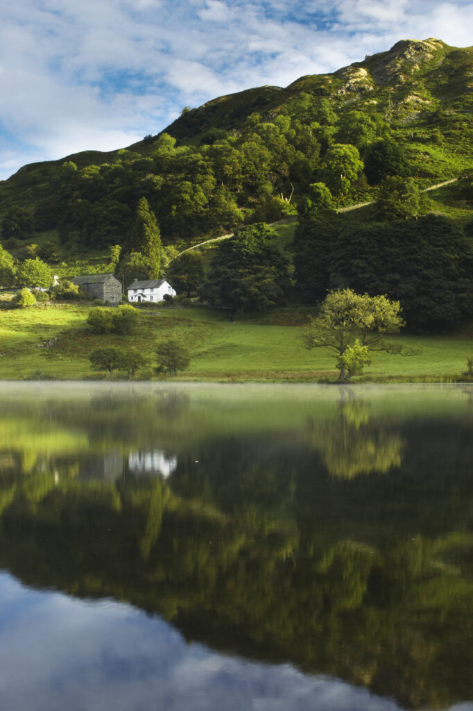 England, Cumbria, Lake District National Park Reflections of typical lake district scenary in the still waters of Loughrigg Tarn